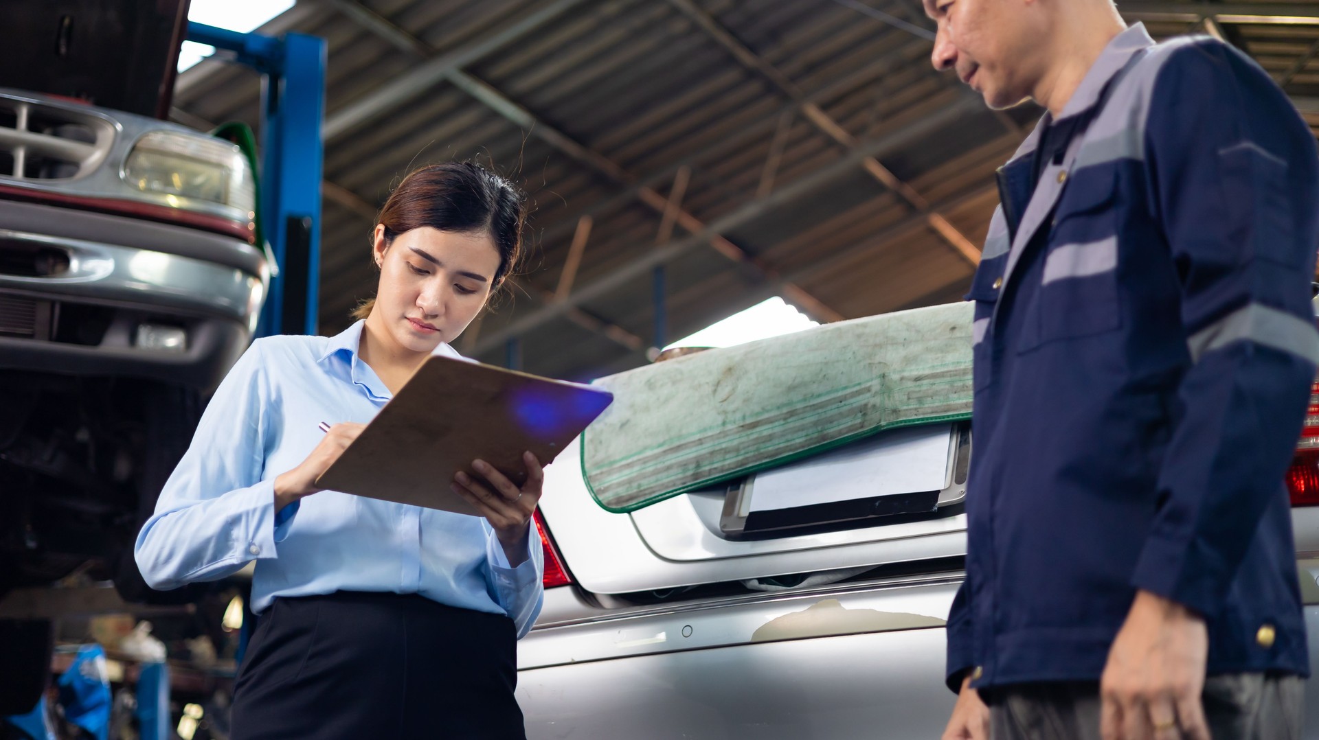 female customer shakes hands with a service claim employee at car repair service and auto store shop.